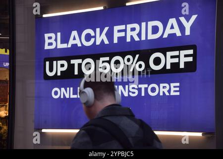 London, Großbritannien. November 2024. Ein Mann läuft an einem Schild in einem Laden in der Oxford Street vorbei, das Rabatte für Black Friday angibt. (Foto: Vuk Valcic/SOPA Images/SIPA USA) Credit: SIPA USA/Alamy Live News Stockfoto