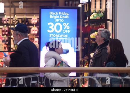 Wien, Österreich. November 2024. Die Leute gehen am 29. November 2024 in einem Einkaufszentrum in Wien vorbei an einem Schild der Verkaufsförderung am Black Friday. Quelle: Han Lu/Xinhua/Alamy Live News Stockfoto