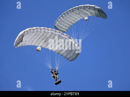 Zwei Fallschirmaufklärer der Schweizer Armee an ihren Fallschirmen. Die Flugshow ZigAirMeet mit internationaler Beteiligung aus dem militärischen und zivilen Luftfahrtbereich fand am 18. Und 19. August 2023 in Mollis, Kanton Glarus, Schweiz, statt. Mollis Glarus Schweiz *** zwei Fallschirmjäger der Schweizer Armee auf ihren Fallschirmen die Luftschau ZigAirMeet mit internationaler Beteiligung aus der Militär- und Zivilluftfahrt fand am 18. Und 19. August 2023 in Mollis, Kanton Glarus, Schweiz Mollis Glarus Schweiz statt Stockfoto
