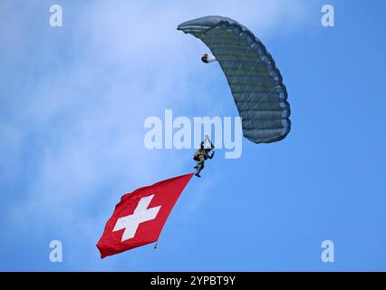 Ein Fallschirmaufklärer der Schweizer Armee an einem Freifallschirm. Er trägt die Schweizer Nationalflagge mit sich. Die Flugshow ZigAirMeet mit internationaler Beteiligung aus dem militärischen und zivilen Luftfahrtbereich fand am 18. Und 19. August 2023 in Mollis, Kanton Glarus, Schweiz, statt. Mollis Glarus Schweiz *** Fallschirmjäger der Schweizer Armee auf einem Freifall-Fallschirm mit Schweizer Nationalflagge die Luftschau ZigAirMeet mit internationaler Beteiligung aus der Militär- und Zivilluftfahrt fand am 18. Und 19. August 2023 in Mollis, Kanton Glarus, Schweiz Mollis Glarus SWI statt Stockfoto