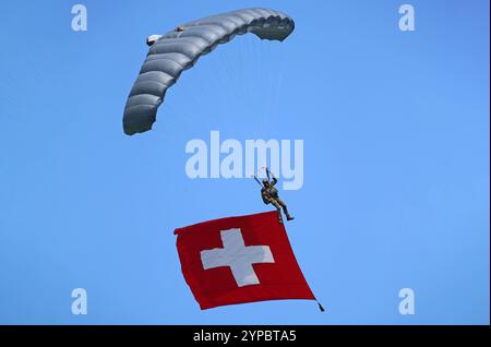 Ein Fallschirmaufklärer der Schweizer Armee an einem Freifallschirm. Er trägt die Schweizer Nationalflagge mit sich. Die Flugshow ZigAirMeet mit internationaler Beteiligung aus dem militärischen und zivilen Luftfahrtbereich fand am 18. Und 19. August 2023 in Mollis, Kanton Glarus, Schweiz, statt. Mollis Glarus Schweiz *** Fallschirmjäger der Schweizer Armee auf einem Freifall-Fallschirm mit Schweizer Nationalflagge die Luftschau ZigAirMeet mit internationaler Beteiligung aus der Militär- und Zivilluftfahrt fand am 18. Und 19. August 2023 in Mollis, Kanton Glarus, Schweiz Mollis Glarus SWI statt Stockfoto