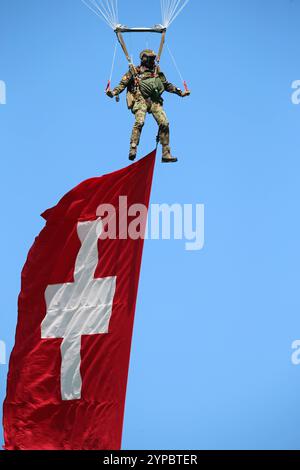 Ein Fallschirmaufklärer der Schweizer Armee am Fallschirm hängend. Er trägt die Schweizer Nationalflagge mit sich. Hochkant. Die Flugshow ZigAirMeet mit internationaler Beteiligung aus dem militärischen und zivilen Luftfahrtbereich fand am 18. Und 19. August 2023 in Mollis, Kanton Glarus, Schweiz, statt. Mollis Glarus Schweiz *** Fallschirmjäger der Schweizer Armee am Fallschirm Er trägt die Schweizer Nationalflagge am Rand die ZigAirMeet Luftschau mit internationaler Beteiligung aus der Militär- und Zivilluftfahrt fand am 18. Und 19. August 2023 in Mollis, Kanton Glarus, Schweiz statt Stockfoto