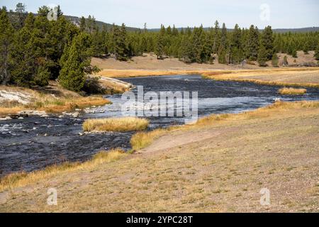 Eine aktive Geysirquelle mit einem periodischen Abfluss von Wasser, das turbulent und mit Dampf begleitet wird, im Yellowstone-Nationalpark, USA Stockfoto