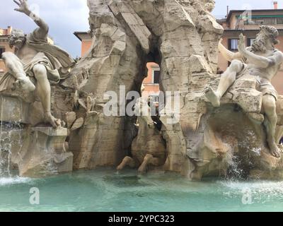 Dieser atemberaubende Brunnen zeigt exquisite Skulpturen, die mythologische Figuren in dynamischen Posen darstellen. Wasser kaskadiert um die Steinfiguren, Kreatin Stockfoto