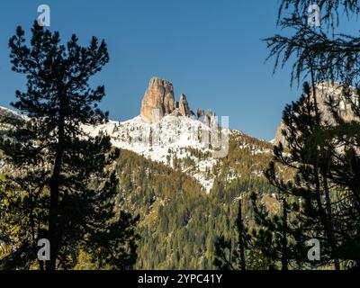 Während sich der Croda di Lago durch goldene Herbstbäume schlängelt, erhebt sich Cinque Torri majestätisch in der Ferne und zeigt die perfekte Harmonie des Falls Stockfoto