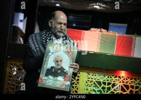 Teheran, Iran. November 2024. Ein iranischer Mann trägt ein Porträt des getöteten iranischen Oberbefehlshabers Qasem Soleimani während der Begräbniszeremonie von Brigadegeneral Kiyomarth Porhashmi, einem hochrangigen Offizier der Quds Force der Islamischen Revolutionsgarde (IRGC), der in Aleppo, Syrien, getötet wurde. Die Quds Force der IRGC ist eine Einheit der iranischen Revolutionsgarde, die Militär-, Geheimdienst- und Unterstützungsoperationen im Ausland durchführt, um den regionalen Einfluss des Iran voranzutreiben. (Kreditbild: © Rouzbeh Fouladi/ZUMA Press Wire) NUR REDAKTIONELLE VERWENDUNG! Nicht für kommerzielle ZWECKE! Stockfoto