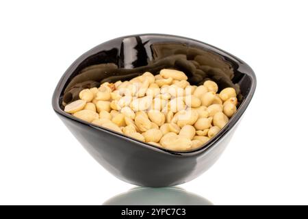 Geröstete köstliche Erdnüsse in einem schwarzen Keramikbecher, Nahaufnahme, isoliert auf weißem Hintergrund. Stockfoto