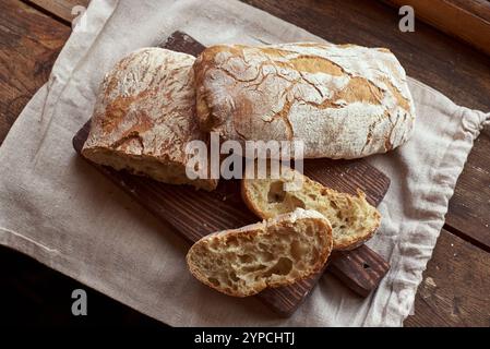 Geschnittenes Brot (Ciabatta) auf einem Holzschneidebrett Stockfoto