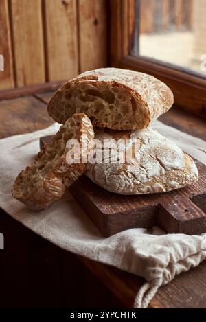 Geschnittenes Brot (Ciabatta) auf einem Holzschneidebrett Stockfoto