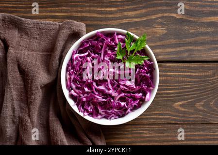 Rotkohl in Schüssel über Holzgrund. Draufsicht, flach Stockfoto