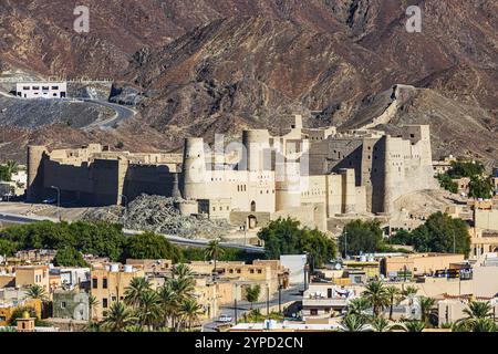 Blick auf die Stadt Bahla, mit der Tonfestung von Hisn Tamah im Hintergrund, Bahla, Arabische Halbinsel, Sultanat Oman Stockfoto