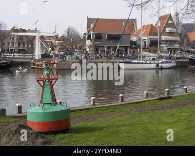 Boje im Hafengebiet mit Segelbooten und traditionellen Kanalhäusern, hoorn, ijsselmeer, niederlande Stockfoto