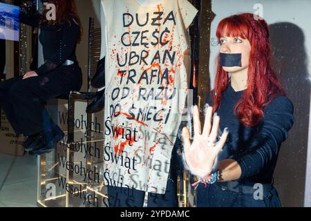 Umweltschützer der Extinction Rebellion klebten sich während des Black Friday an das Zara-Schaufenster, um gegen den konsumierenden Planeten zu protestieren. Eine Person, die den Mund verschlossen hat, wird an ein Fenster geklebt, und auf einem Banner auf einer Schaufensterpuppe steht: Ein großer Teil der Kleidung geht direkt in den Müll. Warschau Polen Copyright: XMikolajxJaneczekx Stockfoto