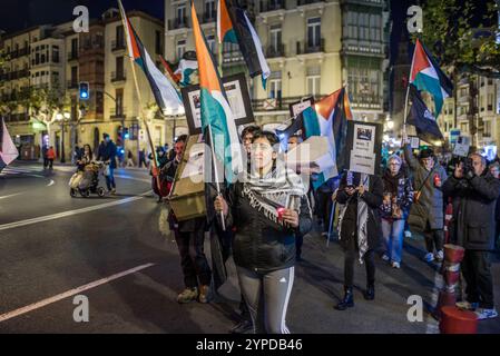 Logroño, La Rioja, Spanien. November 2024. Pro-palästinensische Aktivisten unterbrechen die offizielle Weihnachtsbeleuchtung in Logroño. Mit Kerzen, palästinensischen Fahnen und symbolischen Särgen stehen sie hinter der Bürgermeisterprozession. Ihr stiller Protest zielt darauf ab, den Konflikt in Gaza sichtbar zu machen und einen festlichen Moment in einen Raum für Denunziation und Reflexion über die humanitäre Krise in Palästina zu verwandeln. Quelle: Mario Martija/Alamy Live News. Stockfoto