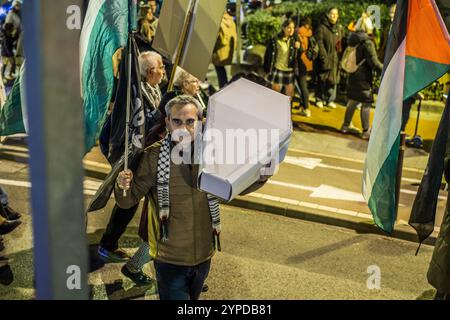 Logroño, La Rioja, Spanien. November 2024. Pro-palästinensische Aktivisten unterbrechen die offizielle Weihnachtsbeleuchtung in Logroño. Mit Kerzen, palästinensischen Fahnen und symbolischen Särgen stehen sie hinter der Bürgermeisterprozession. Ihr stiller Protest zielt darauf ab, den Konflikt in Gaza sichtbar zu machen und einen festlichen Moment in einen Raum für Denunziation und Reflexion über die humanitäre Krise in Palästina zu verwandeln. Quelle: Mario Martija/Alamy Live News. Stockfoto