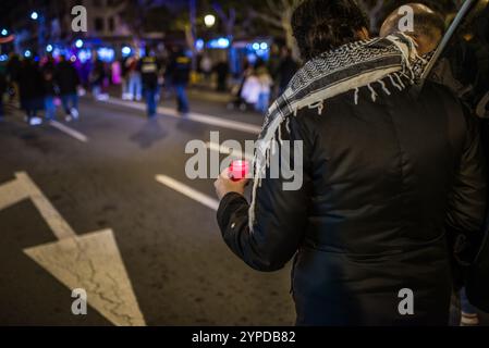 Logroño, La Rioja, Spanien. November 2024. Pro-palästinensische Aktivisten unterbrechen die offizielle Weihnachtsbeleuchtung in Logroño. Mit Kerzen, palästinensischen Fahnen und symbolischen Särgen stehen sie hinter der Bürgermeisterprozession. Ihr stiller Protest zielt darauf ab, den Konflikt in Gaza sichtbar zu machen und einen festlichen Moment in einen Raum für Denunziation und Reflexion über die humanitäre Krise in Palästina zu verwandeln. Quelle: Mario Martija/Alamy Live News. Stockfoto