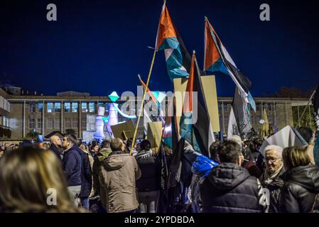 Logroño, La Rioja, Spanien. November 2024. Pro-palästinensische Aktivisten unterbrechen die offizielle Weihnachtsbeleuchtung in Logroño. Mit Kerzen, palästinensischen Fahnen und symbolischen Särgen stehen sie hinter der Bürgermeisterprozession. Ihr stiller Protest zielt darauf ab, den Konflikt in Gaza sichtbar zu machen und einen festlichen Moment in einen Raum für Denunziation und Reflexion über die humanitäre Krise in Palästina zu verwandeln. Quelle: Mario Martija/Alamy Live News. Stockfoto