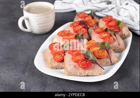 Hausgemachte Sandwiches mit putenpastete und Kirschtomaten sowie eine Tasse Kaffee Stockfoto