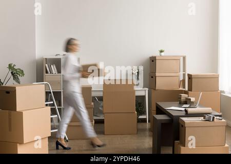 Verschwommenes Bild einer reifen Geschäftsinhaberin mit Kartonschachteln Stockfoto