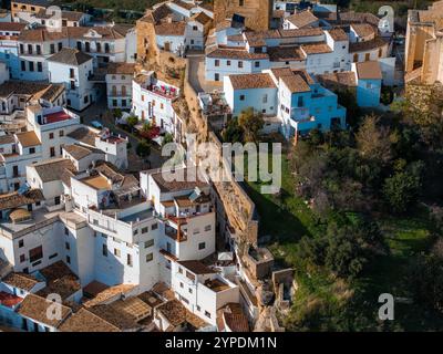 Das Bild zeigt Setenil de las Bodegas von oben und zeigt weiß getünchte Häuser, die in Felsüberhänge gebaut wurden, Terrakotta-Dächer und enge Windungen Stockfoto