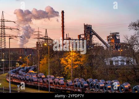 Hochofen Schwelgern 1 und 2, Bandstahl Rollen, Coils, auf Güterwagons, im ThyssenKrupp Steel Werk Schwelgern in Duisburg-Marxloh gehört zum Stahlwerk Bruckhausen, im Hintergrund der Kühlturm des STEAG Kohlekraftwerk Walsum, NRW, Deutschland ThyssenKrupp Steel *** Hochofen Schwelgern 1 und 2, Bandstahlspulen, auf Güterwagen, im Hintergrund Stockfoto