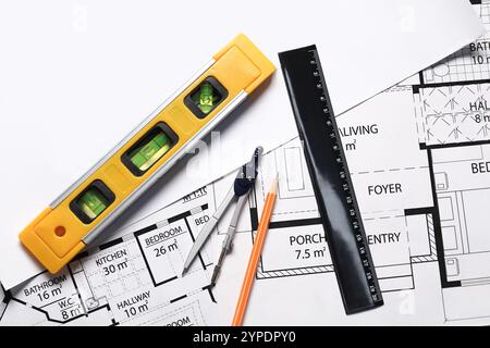 Bleistift, Trennblätter, Gebäudeebene und Lineal auf verschiedenen Architekturzeichnungen, Draufsicht Stockfoto