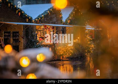 Eine magische Szene auf dem Zürcher Weihnachtsmarkt in der Schweiz, mit funkelnden Lichtern und Schneefall, die ein winterliches Wunderland schaffen, keine Leute Stockfoto
