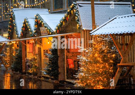 Eine magische Szene auf dem Zürcher Weihnachtsmarkt in der Schweiz, mit funkelnden Lichtern und Schneefall, die ein winterliches Wunderland schaffen, keine Leute Stockfoto