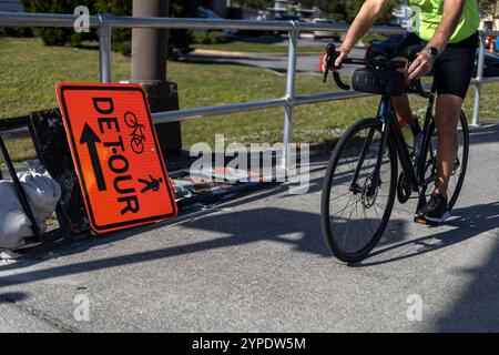 Warnschild auf der Umleitungsstraße, das auf der Straße liegt, während ein Fahrrad davor hält Stockfoto