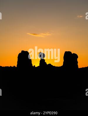 Balanced Rock im Arches National Park, beleuchtet durch leuchtend orange Sonnenaufgang Stockfoto