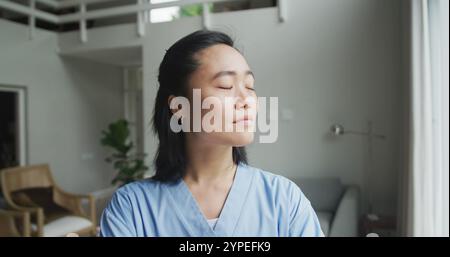 Porträt einer glücklichen asiatischen Krankenschwester bei der Arbeit im Krankenhaus, lächelnd vor die Kamera Stockfoto