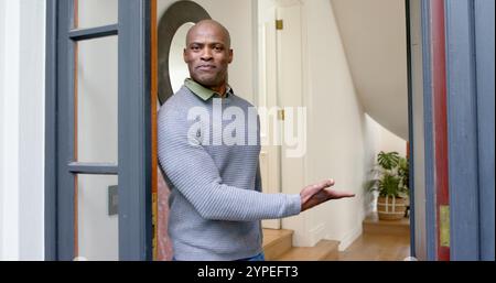 Glücklicher afroamerikaner, der vor seiner Haustür begrüßt wird Stockfoto