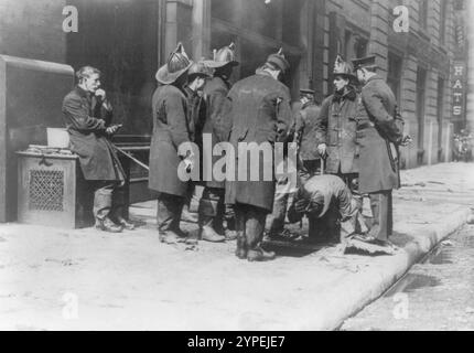 Feuerwehrmänner suchen nach Leichen nach dem Dreieck-Shirtwaist-Brand am 25. März 1911. Der Brand der Triangle Shirtwaist Factory war einer der schlimmsten Industrieunfälle in der US-Geschichte. Im 10. Stock des Asch-Gebäudes brach ein Feuer aus. Die Brandausgänge waren verschlossen, die Brandausgänge unzureichend und die Leiter der Löschfahrzeuge waren nicht lang genug. 146 Menschen wurden getötet, von denen 62 in den Tod sprangen, um den Flammen zu entgehen. Stockfoto