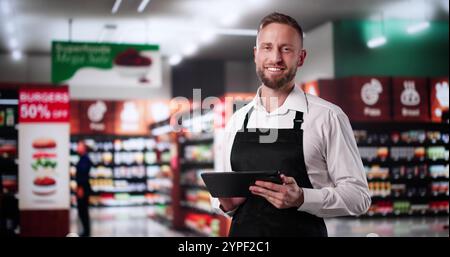 Trainee-Mitarbeiter Im Supermarkt. Glücklicher Mann Im Supermarkt Stockfoto