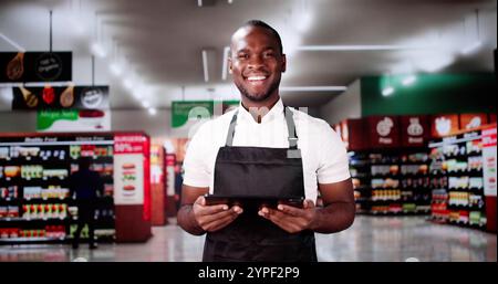 Trainee-Mitarbeiter Im Supermarkt. Glücklicher Mann Im Supermarkt Stockfoto