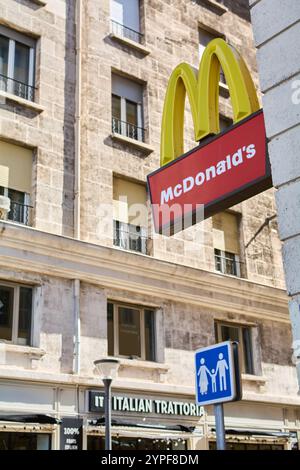 Marseille. Frankreich - 30. November 2024: McDonald-Schild in einer städtischen Umgebung in der Nähe einer italienischen Trattoria, das die vielfältige kulinarische Vielfalt hervorhebt Stockfoto