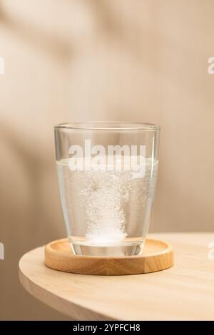 Eine brausende Mukolytika-Tablette löst sich in einem Glas Trinkwasser auf und zeigt ihre schnelle Wirkung beim Abbau von Schleim für eine leichtere Atmungsaktivität Stockfoto