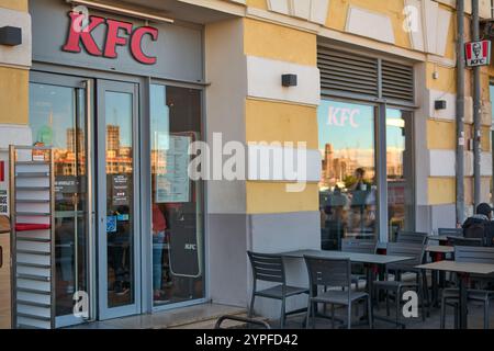 Marseille. Frankreich - 30. November 2024: KFC-Fast-Food-Restaurant mit Sitzplätzen im Freien und Kunden, die drinnen bestellen Stockfoto