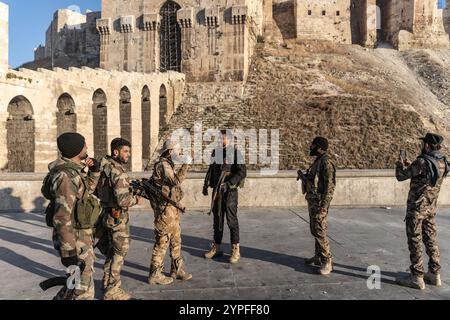 Aleppo, Syrien. November 2024 30. Mitglieder der syrischen bewaffneten Oppositionstruppen stehen vor der antiken Burg Aleppo, nachdem sie die Kontrolle über die meisten Teile der zweitgrößten Stadt Syriens übernommen haben. Anas Alkharboutli/dpa/Alamy Live News Stockfoto