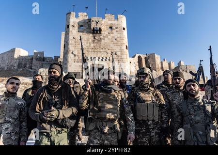 Aleppo, Syrien. November 2024 30. Mitglieder der syrischen bewaffneten Oppositionstruppen stehen vor der antiken Burg Aleppo, nachdem sie die Kontrolle über die meisten Teile der zweitgrößten Stadt Syriens übernommen haben. Anas Alkharboutli/dpa/Alamy Live News Stockfoto