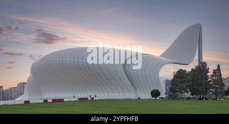 Das Heydar Aliyev Centre in Baku, Aserbaidschan, repräsentiert moderne Architektur mit seinem hügeligen, wellenartigen Design vor der Kulisse des Sonnenuntergangs Stockfoto