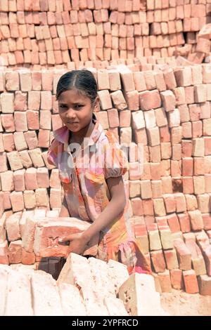 Ein Mädchen, das in einer Ziegelfabrik am Stadtrand von Dhaka, Bangladesch, arbeitet. Stockfoto