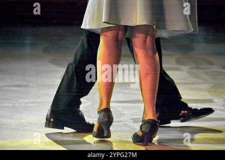 Ein reifes Paar in eleganter Kleidung spielt anmutig einen Walzer auf einer polierten Tanzfläche und unterstreicht ihre raffinierten Tanzfähigkeiten. Stockfoto