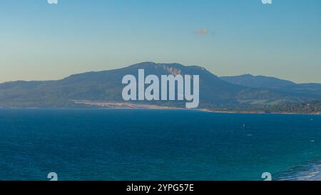 Aus der Vogelperspektive von Tarifa, Spanien, mit dem Meer und der Sierra de San Bartolome. Kitesurfer bestaunen das klare blaue Wasser und sorgen so für mehr Bewegungsfreiheit. Stockfoto