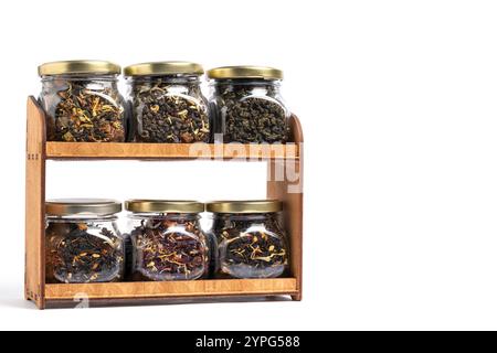 Gläser auf dem Regal mit Teesorten verschiedener Geschmacksrichtungen. Auf weißem Hintergrund Stockfoto