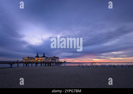 Sellin, Deutschland - 8. Juli 2024: Der Pier von Sellin vor Sonnenaufgang im Sommer, farbenfroher bewölkter Himmel, blaue Stunde Stockfoto