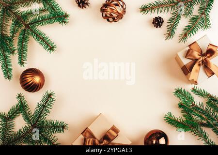 Weihnachtskomposition mit grünen Kiefernzweigen, bronzenen Geschenkboxen mit Bändern und Ornamenten auf beigefarbenem Hintergrund. Draufsicht, flache La Stockfoto