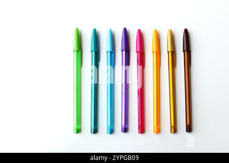 Bunte Stifte nebeneinander auf weißem Hintergrund angeordnet. Kühle Farben in warme Farben. Schreibwaren, Schulbedarf, Kreativkonzept. Stockfoto