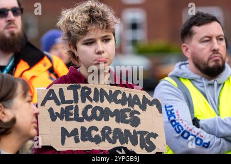 Frau mit dem Schild "Altrincham empfängt Migranten". Am Samstag, den 30. November, fand im Cresta Court Hotel in Altrincham, Greater Manchester, eine Unity Rally statt, um Solidarität mit den im Hotel untergebrachten Flüchtlingen zu zeigen und sich gegen rechtsextreme Proteste zu wehren. Die von Stand Up to Rassismus in Partnerschaft mit den lokalen Gemeindegruppen von Trafford organisierte Kundgebung zielte darauf ab, ein einladendes, integratives Umfeld für Menschen zu fördern, die vor Krieg, Verfolgung und Gewalt fliehen. Cresta Court Hotel, Church Road, Altrincham. Manchester UK Picture Garyroberts/worldwidefeatures.com Stockfoto