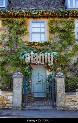 Weihnachtliche Einkäufe im Dorf Broadway in den Cotswolds im Jahr 2024, mit der wunderschönen Weihnachtsdekoration Stockfoto